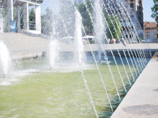 City fountain. Blurred background. Fantana jets, close-up directed upwards.