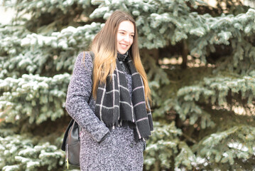 Portrait of a young beautiful long-haired girl in a winter park.