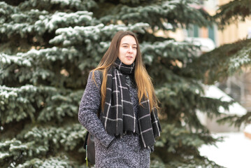 Portrait of a young beautiful long-haired girl in a winter park.