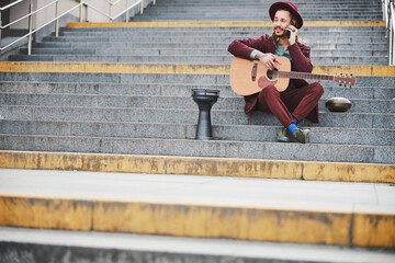Kind male person sitting on stairs outdoors
