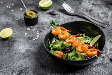 Vegetarian vegetable low carb lunch bowl with avocado, fresh salad, grilled shrimps and pesto sauce. Healthy diet seafood concept. Top view