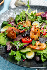 Dietary menu. Healthy salad with cherry tomatoes, cucumber, avocado, eggs and smoked shrimps. Paleo diet