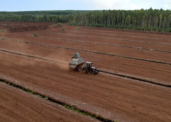 Peat Harvester Tractor on Collecting Extracting Peat. Mining and harvesting peatland. Area drained...