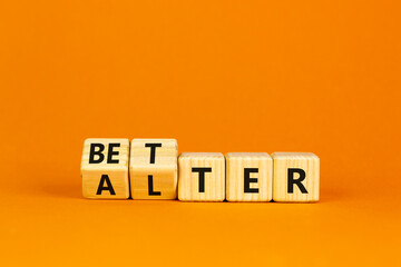 Alter or better symbol. Turned wooden cubes and changed the word 'alter' to 'better'. Beautiful orange background, copy space. Business and alter or better concept.