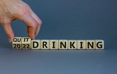Quit drinking 2022 new years resolution symbol. Businessman turns wooden cubes with words '2022 quit drinking'. Beautiful grey background, copy space. Healthy lifestyle and 2022 quit drinking concept.