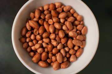 Some nuts on a ceramic bowl on top of glass background