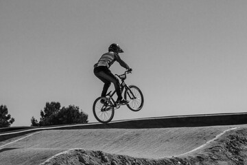 Young boy jumping with a bmx bike in black and white.