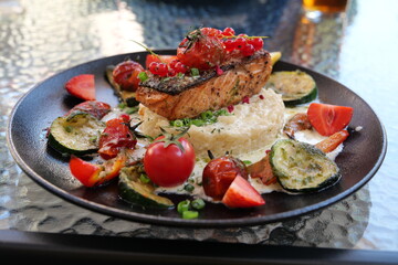 Delicious risotto with baked grilled salmon steak with berries and vegetables. Mediterranean cuisine, healthy food