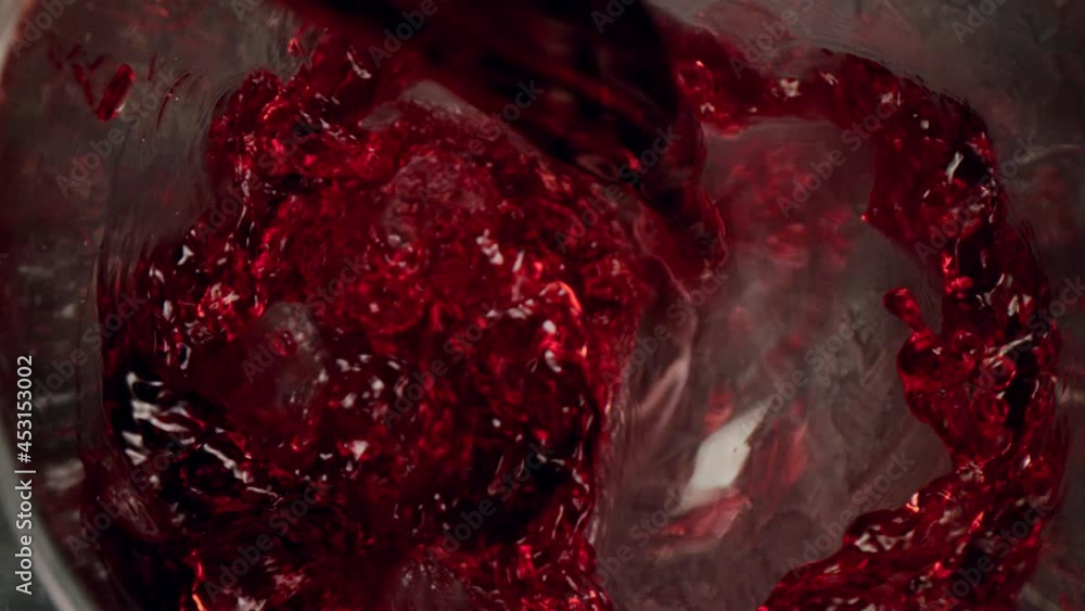 Poster super slow motion of pouring red wine into glass with camera motion. unique angle with underwater ma