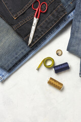 Handicraft, clothing repair. Ripped blue jeans sewing accessories