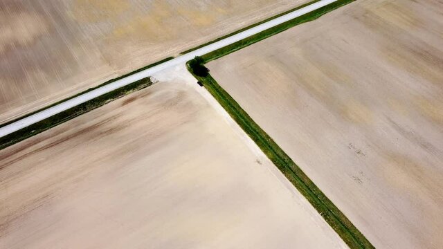 Crossroads T intersection of barren farmland with truck unsure what decision and choice to make