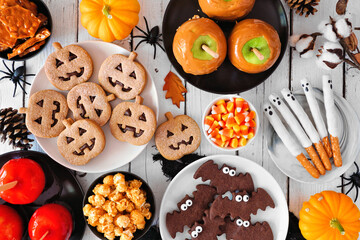 Rustic Halloween treat table scene over a white wood background. Overhead view. Selection of...