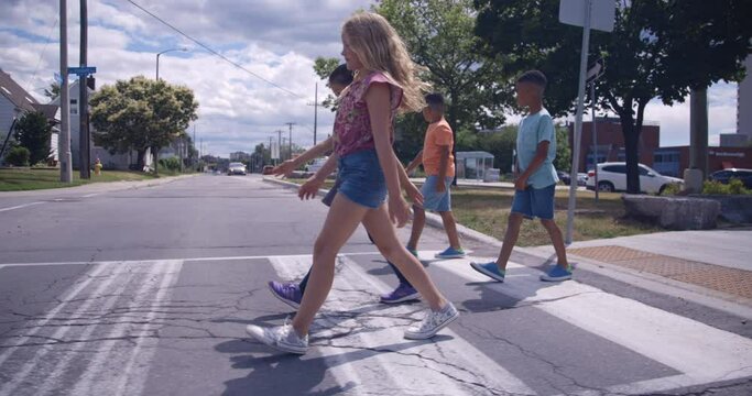diverse group of children crossing the road while walking to school