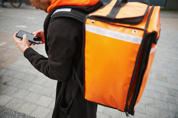 Low angle picture of man looking at smartphone