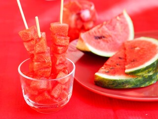 Canape of watermelon slices in a glass glass on a red kitchen napkin. Healthy eating.