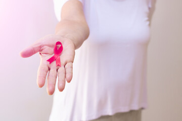 Mature woman with a pink ribbon isolated on white.