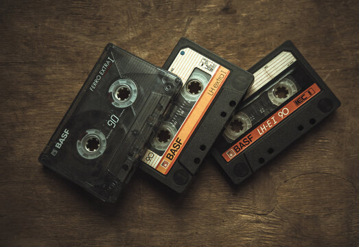 Three basf audio cassettes with magnetic film on a wooden table in a retro style.