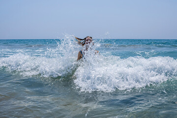 Woman jumping in sea waves
