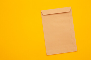 brown envelope front and back isolated on yellow background. View from the letter.