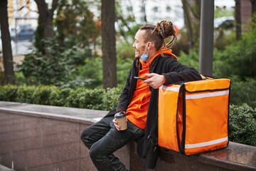 Fototapeta premium Positive delighted courier having rest after work