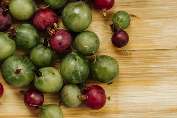 Green and red gooseberries. Gooseberries on a wooden surface