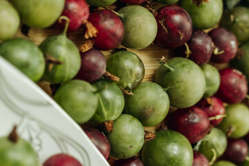 Green and red gooseberries. Gooseberries on a wooden surface