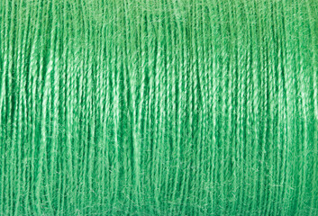 Threads sewing of green color, wound in spool, close-up macro view