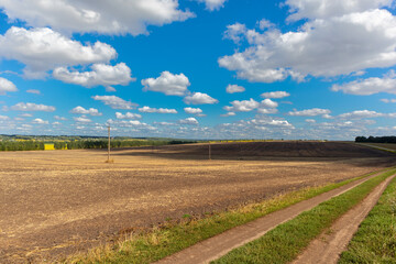 a harvested and plowed field under a cloudy sky