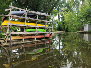 Rack of kayaks along a quiet creek