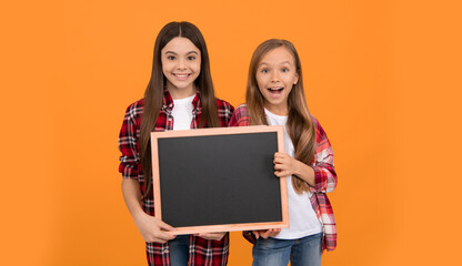 happy teen girls hold blackboard. children advertising. back to school. kids presenting information