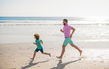 happy dad and child have fun outdoors. father and son running on summer beach.
