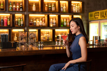 Beautiful woman is drinking cocktail and having enjoy to relaxing while sitting alone to listening music