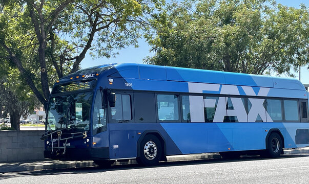 FRESNO, UNITED STATES - Aug 06, 2021: Blue Colored FAX City Bus In Fresno,Ca. Parked Under Green Trees During The Summer