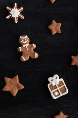 Gift box, stars and man from gingerbread on black background. Traditional pastries. Vertical frame