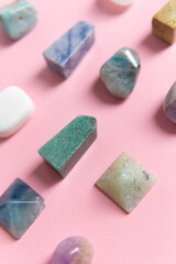 A large collection of beautiful stones. polished gems on a pink background. Geologist exposition.