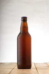 full bottle of beer with drops