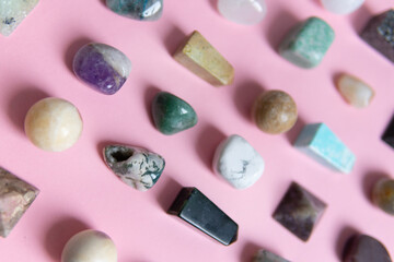 A large collection of beautiful stones. polished gems on a pink background. Geologist exposition.