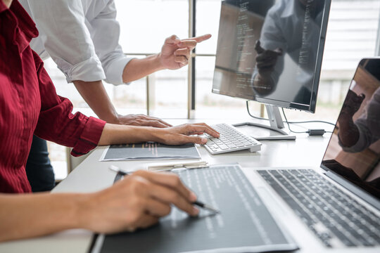 Two professional programmer cooperating and working on web site project in a software developing on desktop computer at company, codes and typing data code, Programming with HTML, PHP and javascript