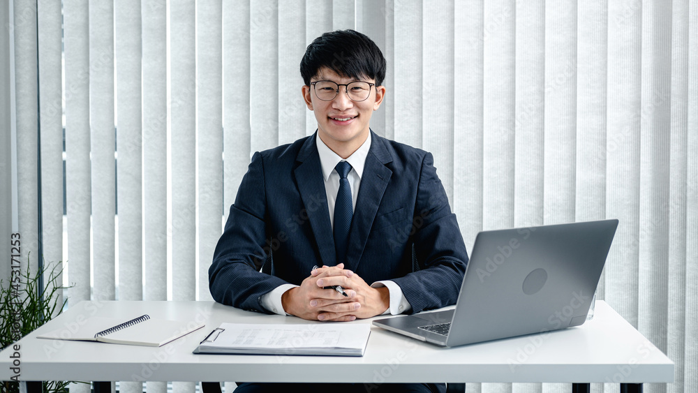 Poster businessman in suit sitting to working in office while writing investment planning on notebook and u