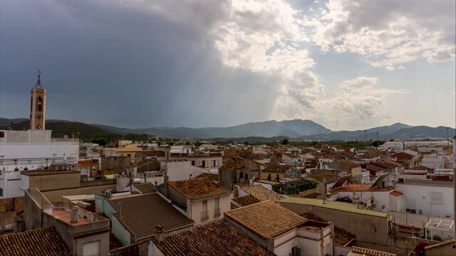 Time lapse video of an urban landscape, with a storm moving away in the sky.