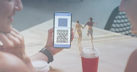Animation of woman holding smartphone with covid 19 vaccination passport over people on the beach