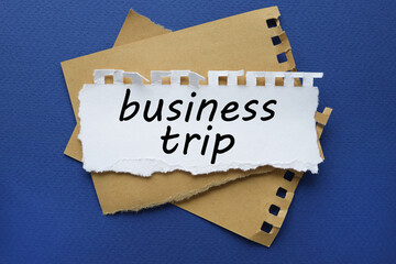business trip, white torn paper with text on blue background