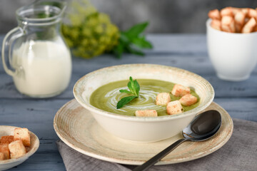 Cream soup in a ceramic plate on a wooden table.