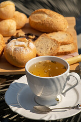 Outdoor afternoon tea, served in a white cup and spoon, with top view