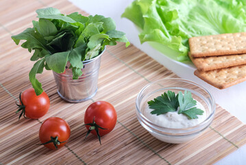 Crispy cracker with herbs and cherries. Still life of eating cookies with sauce and herbs and tomatoes.