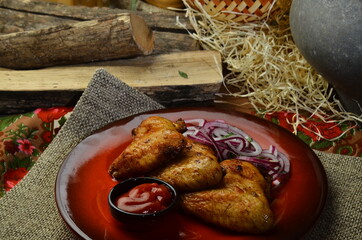 Fried Chicken wing on red plate with natural rustic background