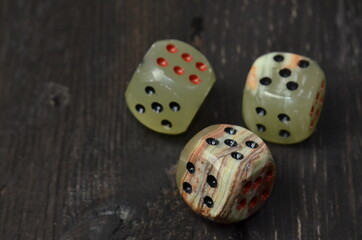 Three dice on dark wooden table background