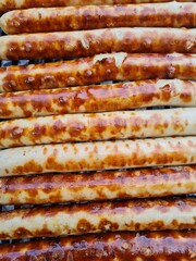 Closeup of many fresh grilled sausages on the grill