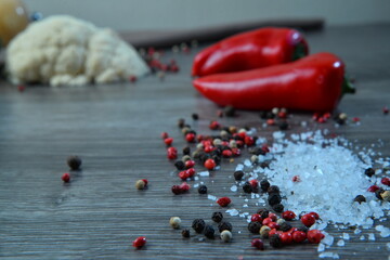 scattered spices and red pepper on dark wooden table closeup view, textile and pepper background