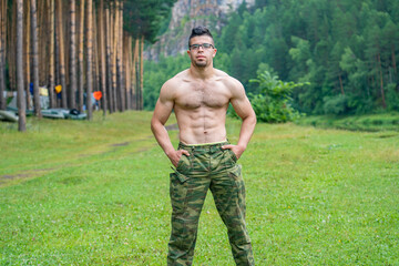 Handsome athletic Arab guy without a T-shirt on the background of the beautiful nature of the South Urals.